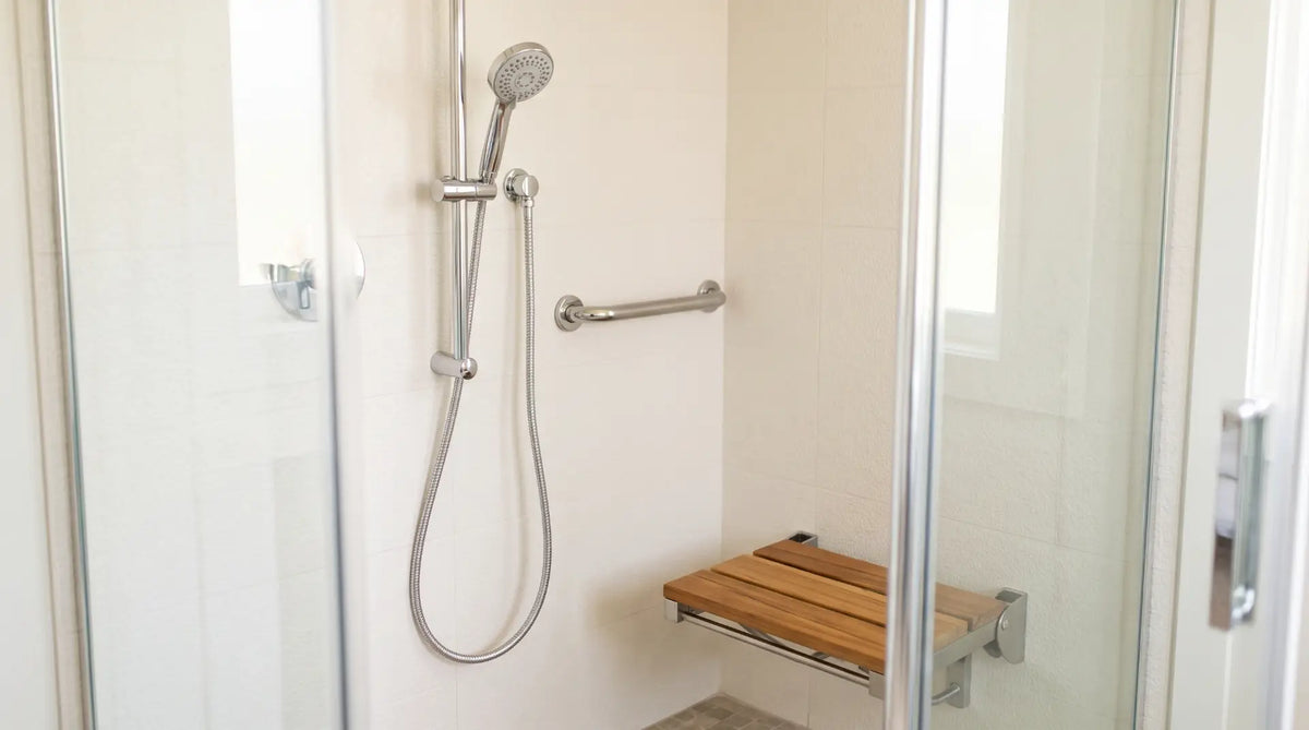 Modern polished chrome handheld shower head mounted on a vertical slide bar inside a bright, accessible Canadian walk-in shower.